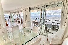 Salón moderno con ventanales al mar, terraza y parrillero