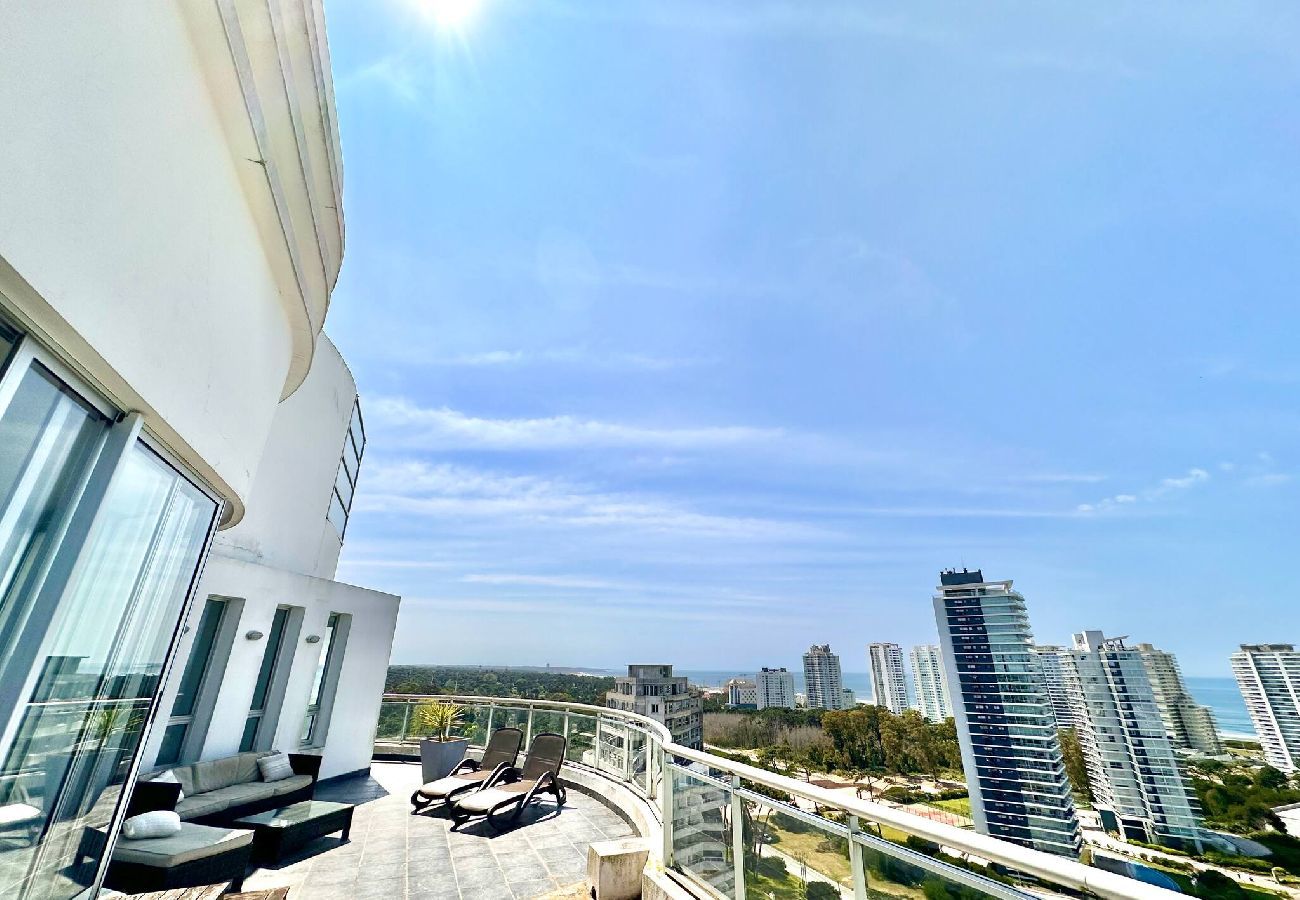 Varanda ampla com móveis externos e churrasqueira em dúplex premium