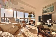 Living room with sofa, TV and large windows with view