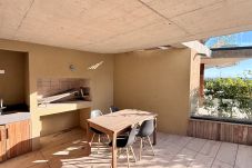 Exclusive barbecue area with table and chairs on covered terrace
